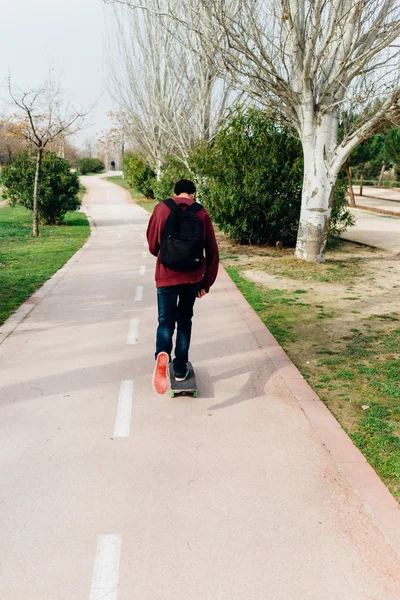 Cara se movendo com seu Skate em um Caminho do Parque — Fotografia de Stock