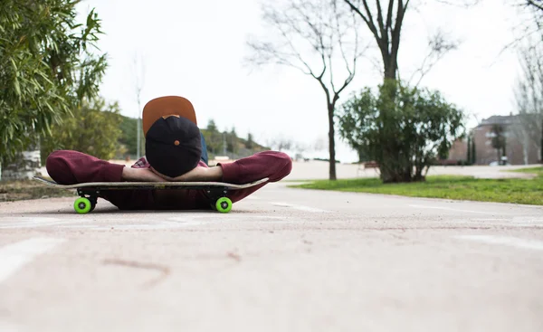 Homem com sua taça descansando sobre ela Skate em um caminho de bicicleta — Fotografia de Stock