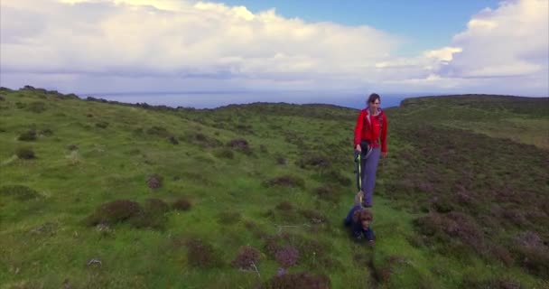 Hiker and dog walking towards Neist Point — ストック動画