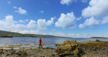 Hiker and dog on a pebble beach