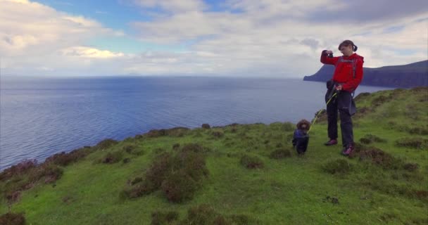 Hiker with dog taking photos of cliff — Stock Video