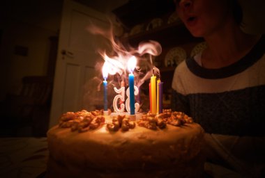 Doğum günü pastasındaki mumları üflüyorum.
