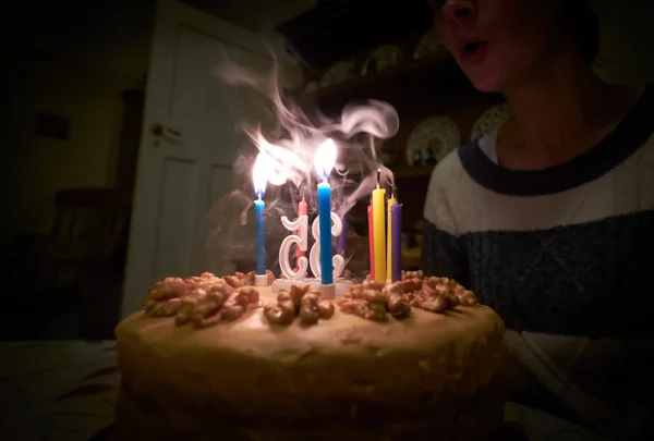 Blowing out candles on a birthday cake — Stock Photo, Image