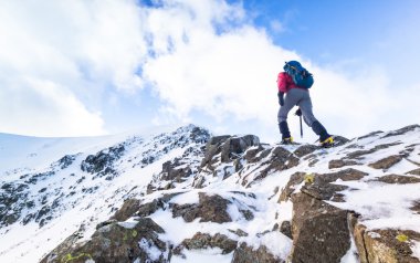 A climber ascending a snow covered ridge  clipart