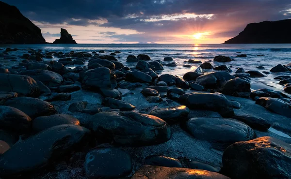 Arena negra y rocas en la orilla del mar — Foto de Stock