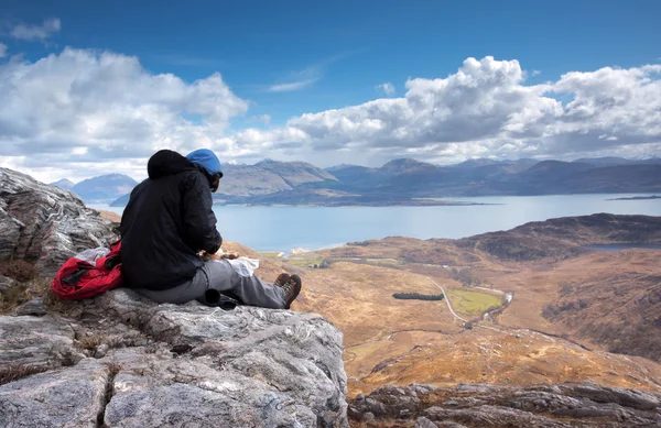 Hiker stops for lunch on rock — Stock Photo, Image