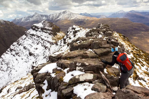 Hiker climbing over peak — Stock Photo, Image
