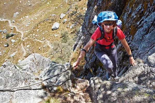Female hiker climbing up on rock — Stock Photo, Image