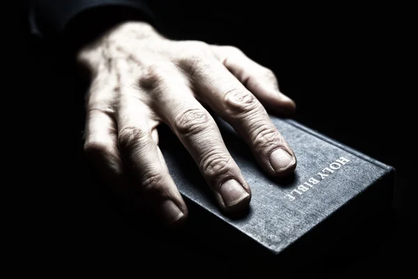 Männliche Hand auf heiliger Bibel — Stockfoto