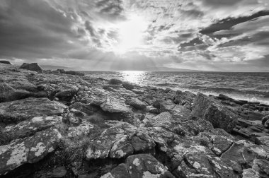 uzak bir kayalık plaj üzerinde son ışığı.