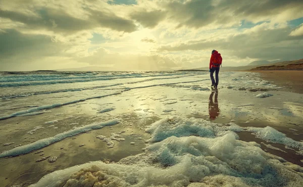 Femme marchant le long de la plage — Photo