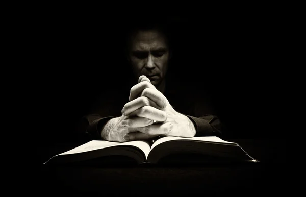 Homme priant sur la Bible — Photo