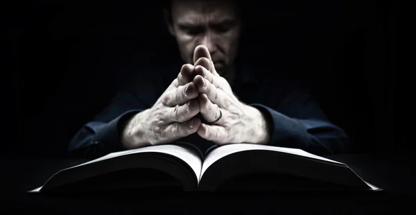 Homem orando sobre a Bíblia — Fotografia de Stock