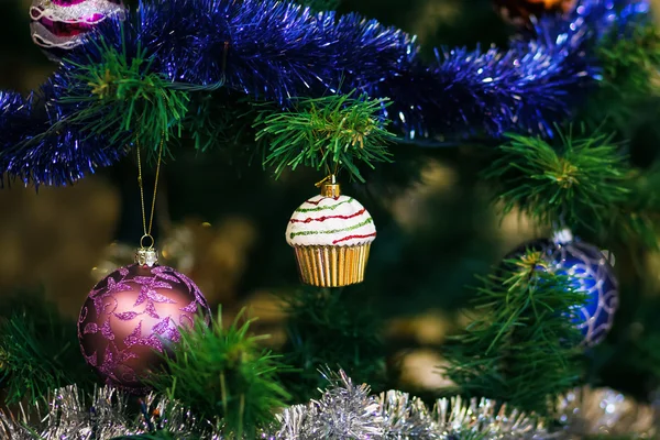 Christmas ball in shape of muffin on Christmas tree. Shallow de — Stock Photo, Image