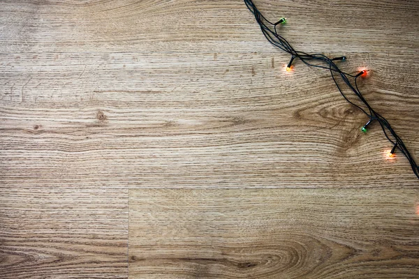 Ghirlanda leggera su fondo di legno . — Foto Stock