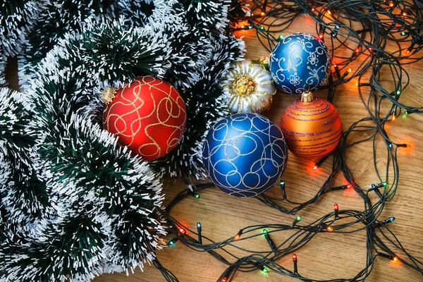 Boules de Noël et guirlande légère sur fond en bois . — Photo