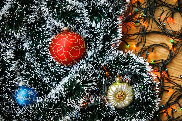 Boules de Noël et guirlande légère sur fond en bois . — Photo