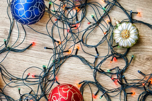 Boules de Noël et guirlande légère sur fond en bois . — Photo