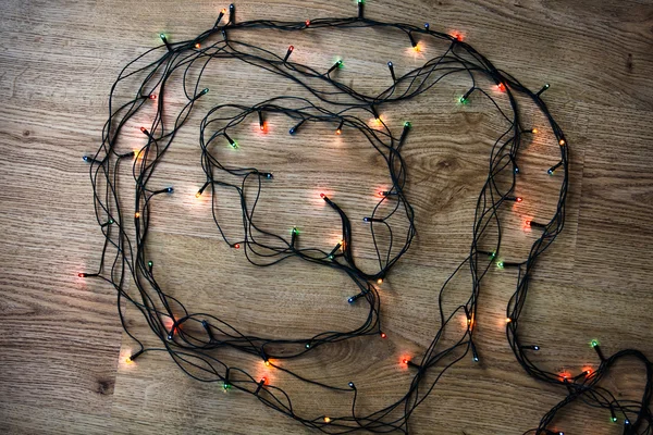 Light garland on wooden background. Underexposure. — Stock Photo, Image