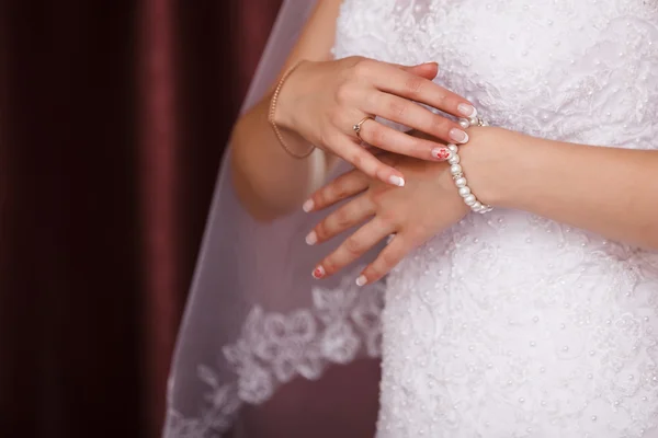 Bride puts on pearl bracelet. Focused on bracelet — Stock Photo, Image