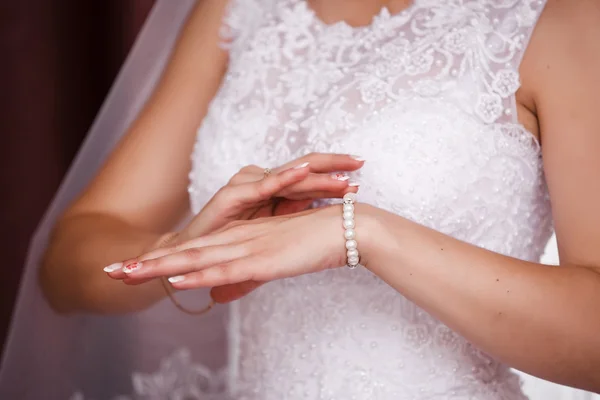 Bride puts on pearl bracelet. Focused on bracelet — Stock Photo, Image