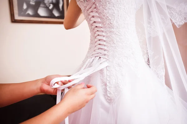 Družička pomáhá nevěstě na svatební šaty. Stock Obrázky