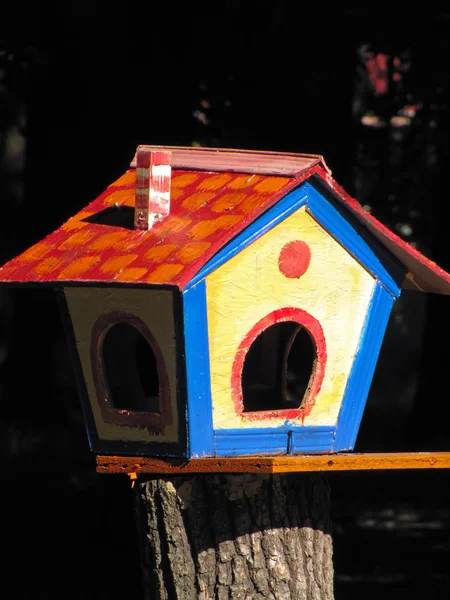 bir ağaç kütüğü üzerinde renkli kuş yuvası