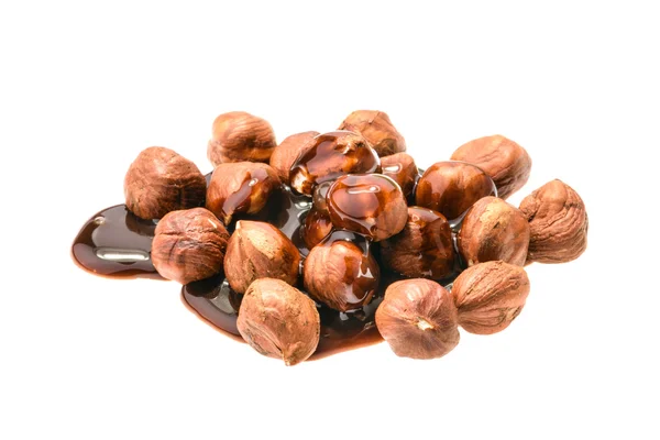 Hazelnuts and chocolate syrup isolated on white — Stock Photo, Image