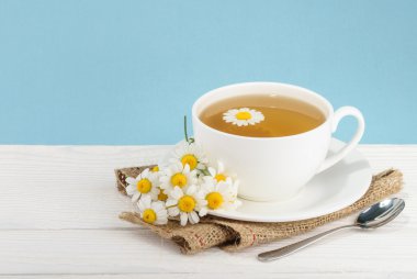 Fincan çay ve chamomiles ahşap arka plan üzerinde