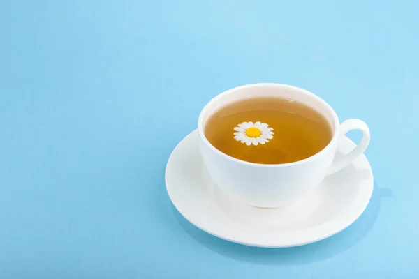 Cup of tea and chamomiles on wooden background — Stock Photo, Image