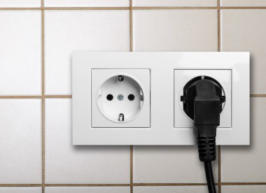 siyah beyaz bir elektrik prizine takılı kablo