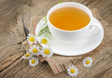 Fincan çay ve chamomiles ahşap arka plan üzerinde
