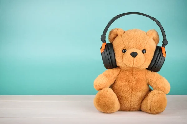 Urso de pelúcia com fones de ouvido com espaço de cópia — Fotografia de Stock