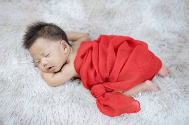 Yün halı arka planında yeni doğmuş şirin bir bebek.