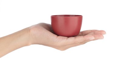 El ele tutuşan çay fincanı beyaz bir arkaplanda izole edilmiş.