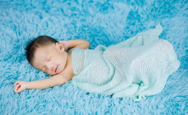 Yeni doğmuş güzel bir bebek, sargı bezi içinde. Rahatlıyor.