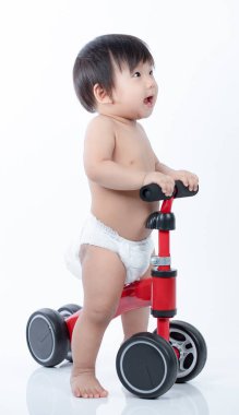 Koşucudaki şirin bebek dengeyi sağlamayı öğreniyor. Bisiklet beyaz arka planda izole edilmiş.