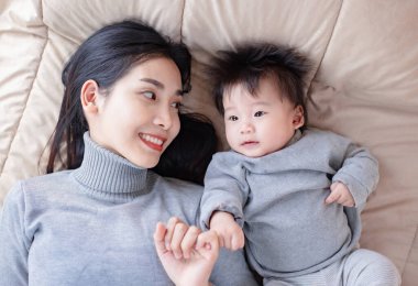 Anne ve bebeğin evde yatakta yatışının en üst görüntüsü.