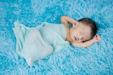 Yün halı arka planında yeni doğmuş şirin bir bebek.