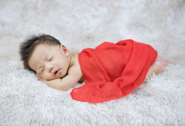 Yün halı arka planında yeni doğmuş şirin bir bebek.