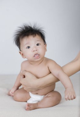 Sevimli bebek annesinin yanında oturmayı öğreniyor.