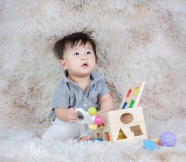 Sevimli bebek tahta oyuncak kutusunu parlak renklerle oynuyor. 