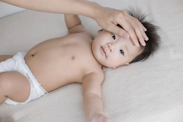 Recém Nascido Está Deitado Cama Mãe Mão Tocar Sua Testa — Fotografia de Stock