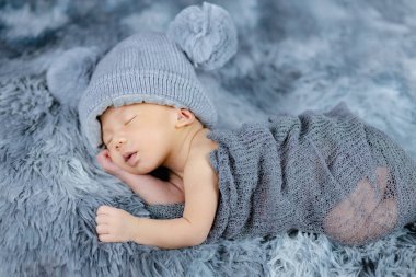 Gri yün halılarda çiçek bandı takan şirin Newborn 'u kapat, moda konsepti.