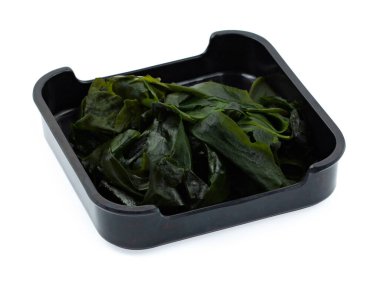 Beyaz arka planda ıslanmış wakame deniz yosunu 