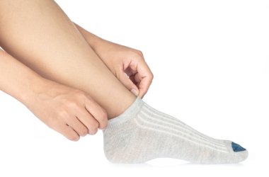 Beyaz arka planda parlayan pamuklu çorap giyen genç kadın..