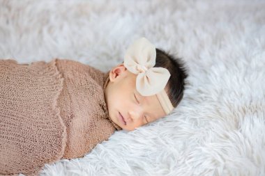 Şirin bir Newborn saç bandı takıyor yün halılara, moda konseptine