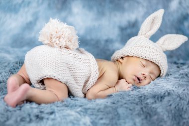 Tavşan kostümü giyen bebek örgü ördü.