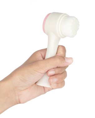 El ele tutuşan yüz temizleme fırçası beyaz arka planda izole edildi