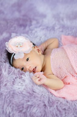 Mor yün halılarda çiçek bandı takan şirin Yenidoğan 'ı kapat, moda kavramı.